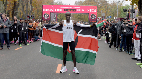Eliud Kipchoge pózuje s keňskou vlajkou.