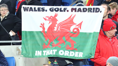 Jeden z fanoušků Walesu držící zmíněnou vlajku během utkání.