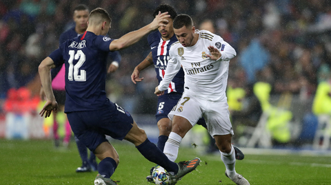 Eden Hazard z Realu (v bílém) dělá kličku Thomasi Meunierovi z PSG.