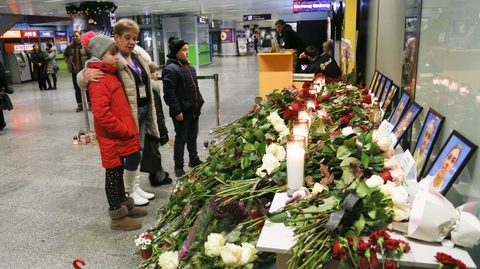Lidé kladou květiny na kyjevském letišti.