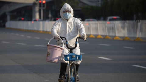 Muž v ochranném obleku v Číně.