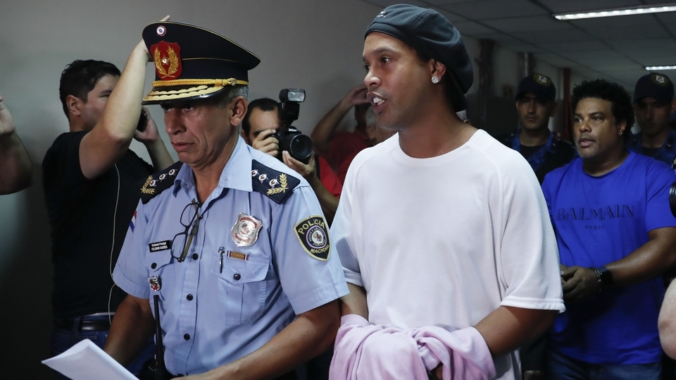 Ronaldinho je odváděn v policejním doprovodu.