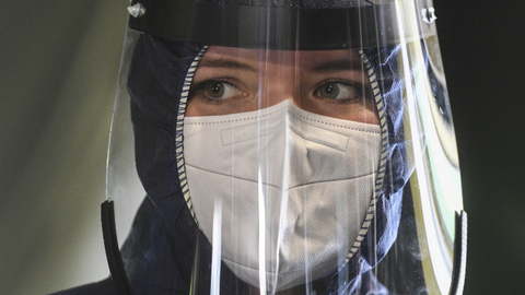 Zdravotnice v ochranném obleku.