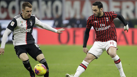 Aaron Ramsey (vlevo) z Juventusu a proti němu hráč AC Milán Hakan Calhanoglu.