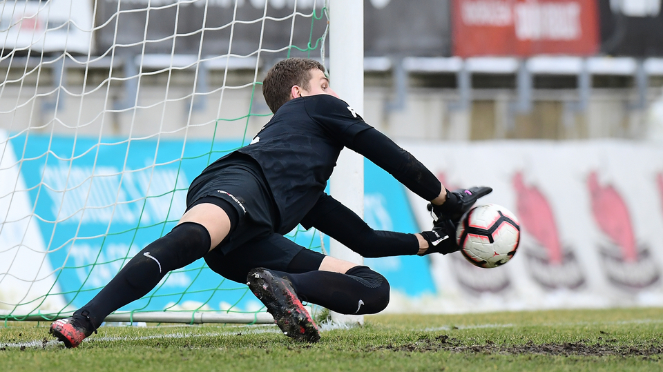 Brankář Ondřej Kočí chytá penaltu.