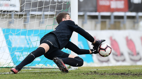 Brankář Ondřej Kočí chytá penaltu.