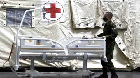 Voják pomáhá v polní nemocnici v Praze.