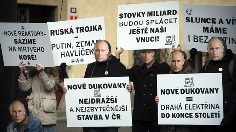 Demonstranti s transparenty a v maskách ruského prezidenta Vladimira Putina.