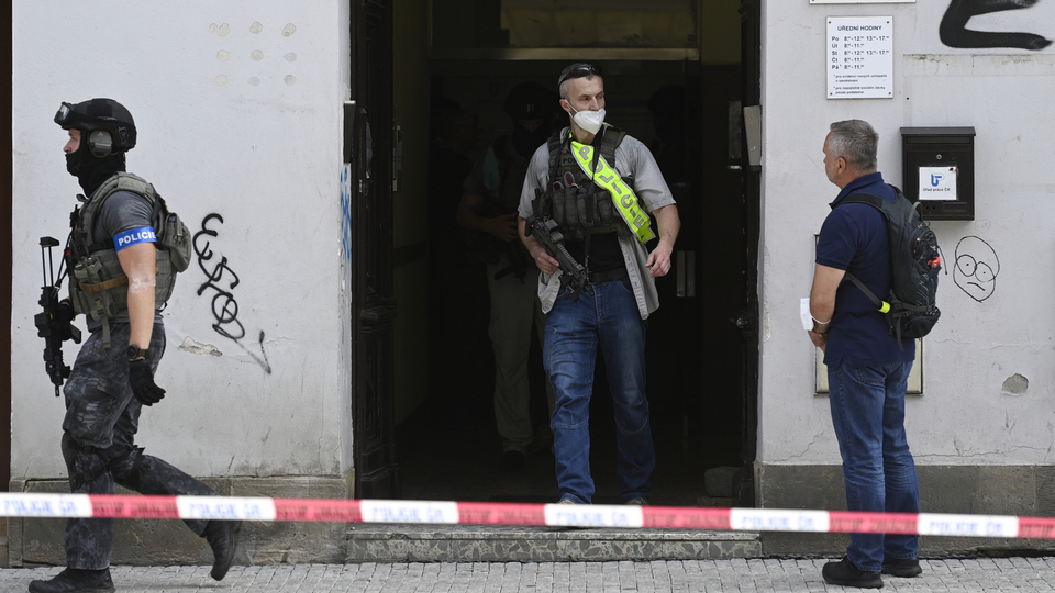 Policisté vycházejí z budovy v Bělehradské ulici v Praze na Vinohradech, kde 29. června 2021 muž postřelil pracovnici úřadu práce.
