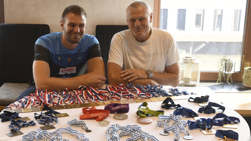 Nejúspěšnější český veslař historie Ondřej Synek (vlevo) ukazuje sbírku svých medailí po tiskové konferenci 23. září 2021 v Praze, kde oznámil ukončení aktivní kariéry. Vpravo je trenér Milan Doleček.