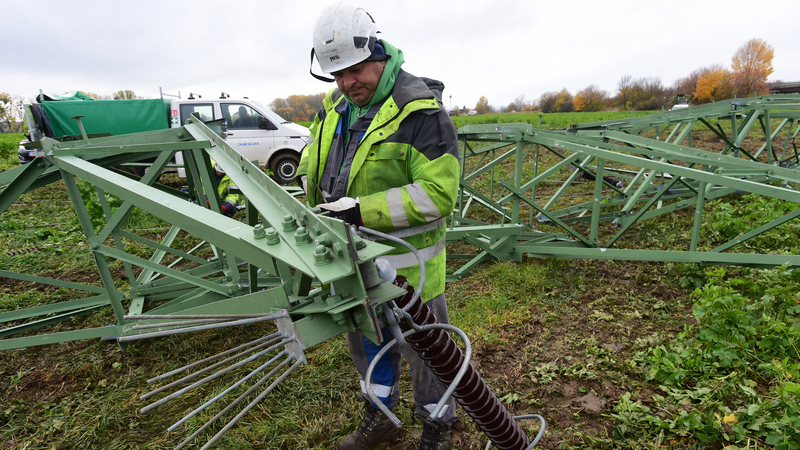 Specializovaní pracovníci 3. listopadu 2021 na poli u Velkého Týnce na Olomoucku demontují jeden ze dvou stožárů vysokého napětí, které poškodil náraz traktoru.